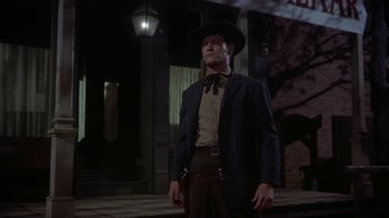 Movie still from “Gunfight at the O.K. Corral” (1957), directed by John Sturges – A man wearing a cowboy hat and a suit; Medium shot, Low angle