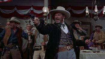 Movie still from “Gunfight at the O.K. Corral” (1957), directed by John Sturges – A man in a cowboy hat holding up a gun; Medium shot, Low angle