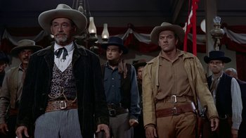 Movie still from “Gunfight at the O.K. Corral” (1957), directed by John Sturges – A group of men standing next to each other wearing cowboy hats; Medium shot, Low angle