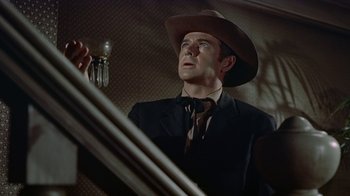 Movie still from “Gunfight at the O.K. Corral” (1957), directed by John Sturges – A man wearing a cowboy hat looking up at the ceiling; Close Up shot, Low angle