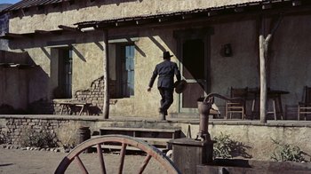 Movie still from “Gunfight at the O.K. Corral” (1957), directed by John Sturges – A man walking down the steps of an old house; Wide shot, Low angle