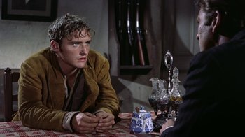 Movie still from “Gunfight at the O.K. Corral” (1957), directed by John Sturges – A man sitting at a table with a teapot; Medium shot, Over the shoulder angle
