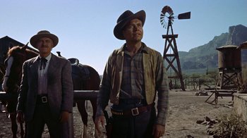 Movie still from “Gunfight at the O.K. Corral” (1957), directed by John Sturges – A man in a cowboy hat standing in front of a windmill; Medium shot, Low angle