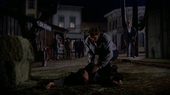 Movie still from “Gunfight at the O.K. Corral” (1957), directed by John Sturges – Two men are fighting in the middle of the night; Wide shot, Over the shoulder angle