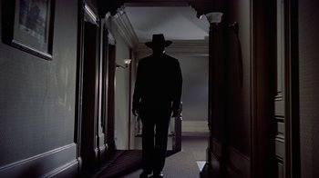 Movie still from “Gunfight at the O.K. Corral” (1957), directed by John Sturges – A man wearing a hat walking down a hall way; Wide shot, Low angle