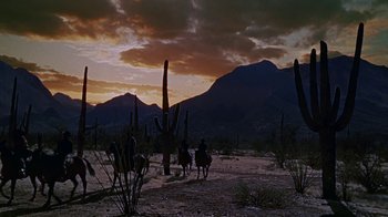 Movie still from “Gunfight at the O.K. Corral” (1957), directed by John Sturges – Two people ride horses in the desert at sunset; Extreme Wide shot, Low angle