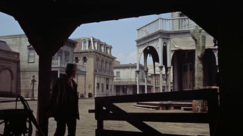 Movie still from “Gunfight at the O.K. Corral” (1957), directed by John Sturges – A person standing in front of an old building; Wide shot, Low angle