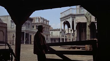 Movie still from “Gunfight at the O.K. Corral” (1957), directed by John Sturges – A man standing in front of an old building; Wide shot, Low angle