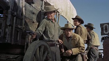 Movie still from “Gunfight at the O.K. Corral” (1957), directed by John Sturges – A group of men standing next to each other on a wagon; Medium shot, Low angle