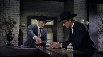 Movie still from “Gunfight at the O.K. Corral” (1957), directed by John Sturges – Two men in suits and black hats are playing a game of cribbage; Medium shot, Low angle