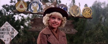 Movie still from “Gypsy” (1962), directed by Mervyn LeRoy – A young girl wearing a brown coat and a hat; Close Up shot, Low angle