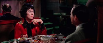 Movie still from “Gypsy” (1962), directed by Mervyn LeRoy – A woman sitting at a dinner table with a man; Medium shot, Over the shoulder angle