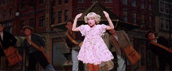 Movie still from “Gypsy” (1962), directed by Mervyn LeRoy – A young girl in a pink dress and a boy in a brown jacket; Medium shot, Low angle