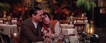 Movie still from “Gypsy” (1962), directed by Mervyn LeRoy – An older man and a younger woman sitting at a dinner table; Medium shot, High angle