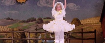 Movie still from “Gypsy” (1962), directed by Mervyn LeRoy – A little girl in a white dress and a white hat; Medium shot, Low angle