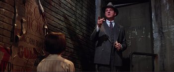 Movie still from “Gypsy” (1962), directed by Mervyn LeRoy – A man wearing a suit and hat talking to a woman; Medium shot, Low angle