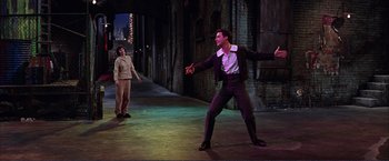 Movie still from “Gypsy” (1962), directed by Mervyn LeRoy – A man in a purple suit and a man in a brown suit; Wide shot, High angle