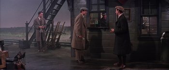 Movie still from “Gypsy” (1962), directed by Mervyn LeRoy – A man in a brown coat and a man in a brown hat; Wide shot, Over the shoulder angle