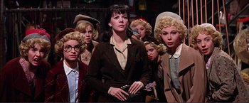 Movie still from “Gypsy” (1962), directed by Mervyn LeRoy – A group of women standing next to each other; Medium shot, Low angle