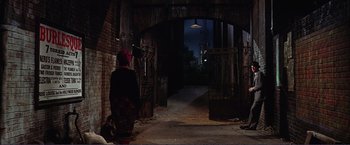 Movie still from “Gypsy” (1962), directed by Mervyn LeRoy – An old woman walking down a dark alley way at night; Wide shot, High angle