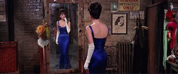 Movie still from “Gypsy” (1962), directed by Mervyn LeRoy – A woman in a blue dress looking in the mirror; Medium shot, Over the shoulder angle