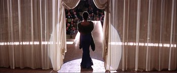 Movie still from “Gypsy” (1962), directed by Mervyn LeRoy – A woman walking down a runway in a dress; Wide shot, Low angle