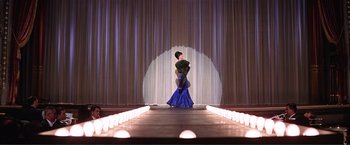 Movie still from “Gypsy” (1962), directed by Mervyn LeRoy – A woman in a blue dress on a runway; Wide shot, Low angle