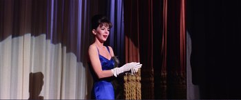 Movie still from “Gypsy” (1962), directed by Mervyn LeRoy – A woman in a blue dress and white gloves; Medium shot, Low angle