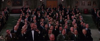 Movie still from “Gypsy” (1962), directed by Mervyn LeRoy – A group of men in suits and ties sitting in a room; Wide shot, High angle