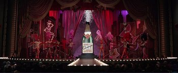 Movie still from “Gypsy” (1962), directed by Mervyn LeRoy – A stage with a large bottle of champagne on it; Extreme Wide shot, High angle