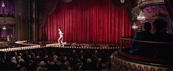 Movie still from “Gypsy” (1962), directed by Mervyn LeRoy – A man standing on a stage in front of an audience; Extreme Wide shot, High angle