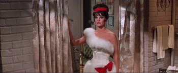 Movie still from “Gypsy” (1962), directed by Mervyn LeRoy – A woman in a white dress and a red bow; Medium shot, Low angle