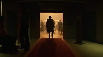 Movie still from “Hands of Stone” (2016), directed by Jonathan Jakubowicz – A man walking down a red carpet through a doorway; Wide shot, Low angle