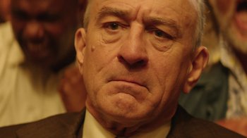 Movie still from “Hands of Stone” (2016), directed by Jonathan Jakubowicz – An older man with a frowning look on his face; Close Up shot, Over the shoulder angle