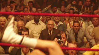 Movie still from “Hands of Stone” (2016), directed by Jonathan Jakubowicz – A man taking a picture in a boxing ring; Wide shot, High angle