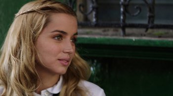 Movie still from “Hands of Stone” (2016), directed by Jonathan Jakubowicz – A beautiful young lady sitting in front of a green fence; Close Up shot, Over the shoulder angle