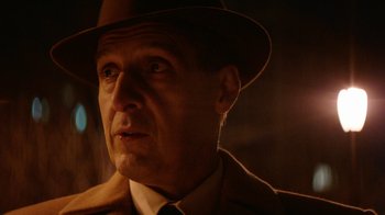 Movie still from “Hands of Stone” (2016), directed by Jonathan Jakubowicz – A person wearing a suit and hat; Close Up shot, Over the shoulder angle