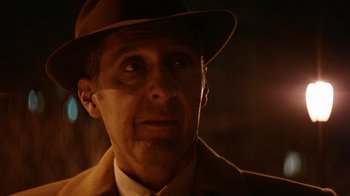Movie still from “Hands of Stone” (2016), directed by Jonathan Jakubowicz – A person wearing a suit and hat; Close Up shot, Over the shoulder angle