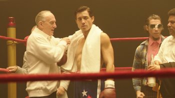 Movie still from “Hands of Stone” (2016), directed by Jonathan Jakubowicz – A man in a boxing ring getting ready for a fight; Medium shot, Over the shoulder angle