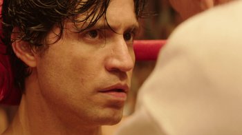 Movie still from “Hands of Stone” (2016), directed by Jonathan Jakubowicz – A man's face in a room; Close Up shot, Over the shoulder angle