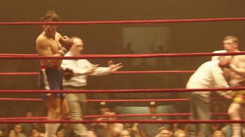 Movie still from “Hands of Stone” (2016), directed by Jonathan Jakubowicz – A crowd of people in a boxing ring watching; Wide shot, High angle
