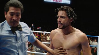 Movie still from “Hands of Stone” (2016), directed by Jonathan Jakubowicz – A person in a boxing ring; Medium shot, Over the shoulder angle