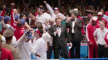Movie still from “Hands of Stone” (2016), directed by Jonathan Jakubowicz – A group of men in suits and ties holding microphones in front of a crowd; Wide shot, High angle