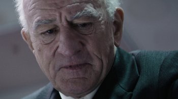 Movie still from “Hands of Stone” (2016), directed by Jonathan Jakubowicz – An older man in a suit looking sad; Close Up shot, Over the shoulder angle