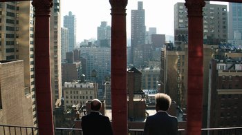 Movie still from “Hands of Stone” (2016), directed by Jonathan Jakubowicz – Two men in suits looking out over a city skyline; Wide shot, Over the shoulder angle