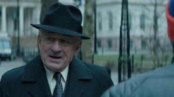 Movie still from “Hands of Stone” (2016), directed by Jonathan Jakubowicz – An older man wearing a black hat and a black suit; Close Up shot, Over the shoulder angle