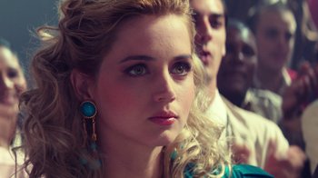 Movie still from “Hands of Stone” (2016), directed by Jonathan Jakubowicz – A beautiful young woman with a blue earring; Close Up shot, Over the shoulder angle