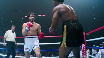 Movie still from “Hands of Stone” (2016), directed by Jonathan Jakubowicz – Two boxers in a boxing ring during a match; Medium shot, Over the shoulder angle