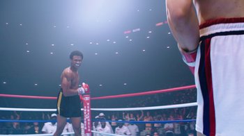 Movie still from “Hands of Stone” (2016), directed by Jonathan Jakubowicz – Two boxers in a boxing ring in front of an audience; Wide shot, Low angle