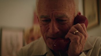 Movie still from “Hands of Stone” (2016), directed by Jonathan Jakubowicz – An older man talking on a phone while sitting at a table; Close Up shot, Low angle